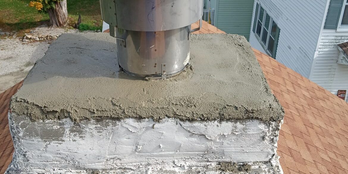 Chimney liner and cap – Brooklyn, CT Painted masonry chimney with a repaired crown and stainless cap in Brooklyn, CT.