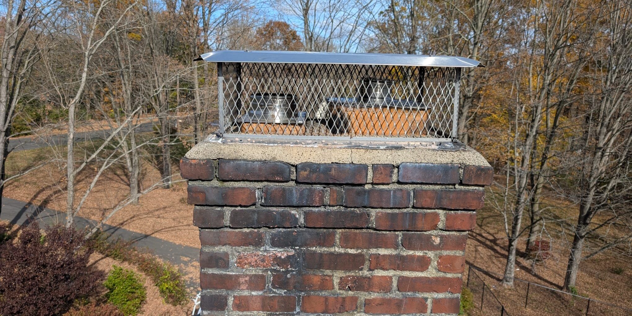 Chimney and protective cap – Durham, CT Brick chimney with a protective metal cap following completed work in Durham, CT.