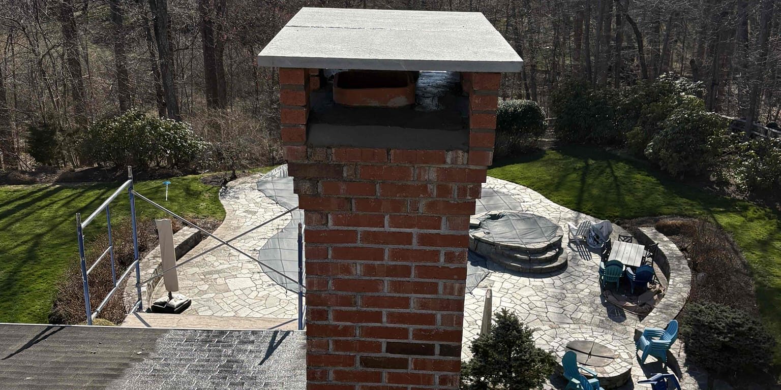 Chimney and bluestone cap – Easton, CT Repaired brick chimney with a new bluestone cap in Easton, CT.
