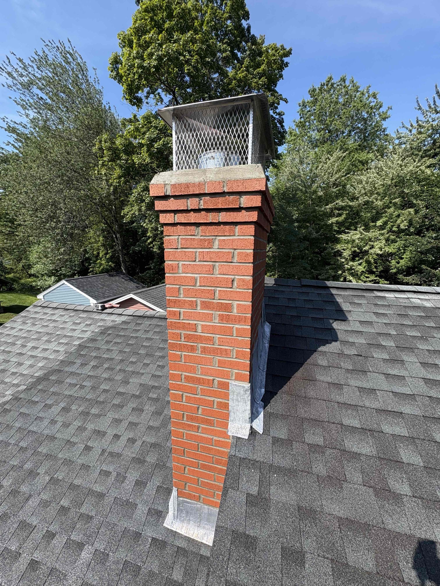 newington-completed-chimney-rebuild Completed brick chimney rebuild with stainless-steel multi-flue cap in Newington, CT